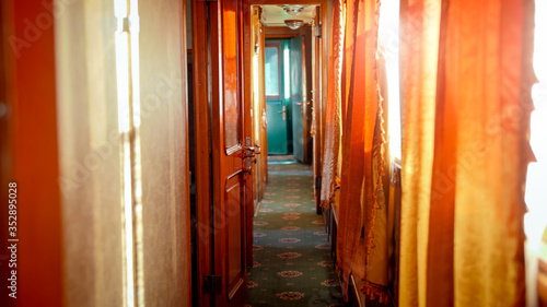 Beautiful interior of retro steam train car with wooden doors and carpets on floor