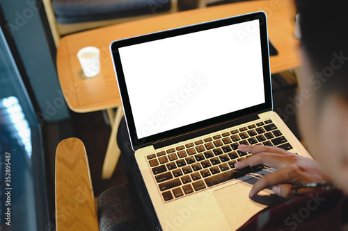 Close up of man using blank laptop order products  for shopping online within the cafe.