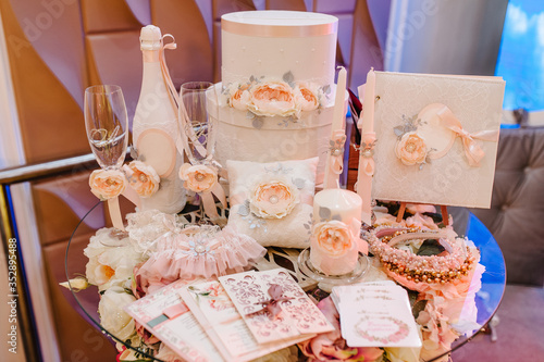 Canvas Print Wedding accessories, invitation, box, glasses, champagne, candles, brides garter lying on the table