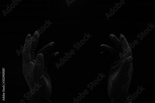 hands in black gloves in the darkness