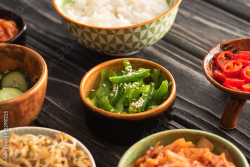 Billede på lærred selective focus of sesame on green bell peppers near rice and korean side dishes