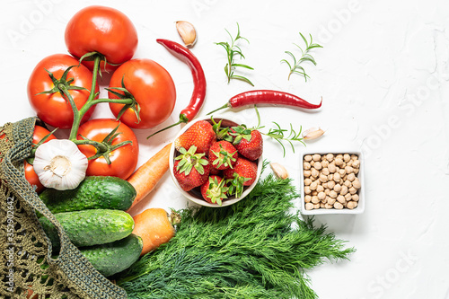 Eco shopping and zero waste concept. Healthy and organic vegetables  fruit and herbs in reusable handmade shopping bag on white concrete background. Farmer   s market and food delivery background.