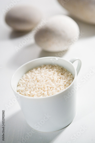 Round grain rice in the white cup and eggs ready for cooking © Pablo