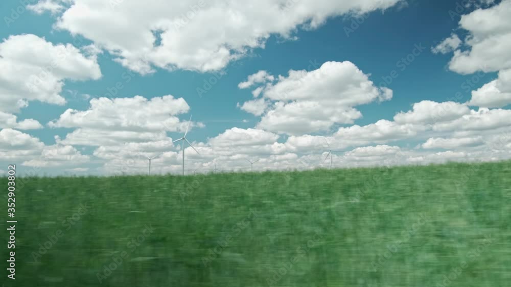 Ride through the countryside along the fields and wind turbines. View from car window Ride through the countryside along the fields and wind turbines. View from car window