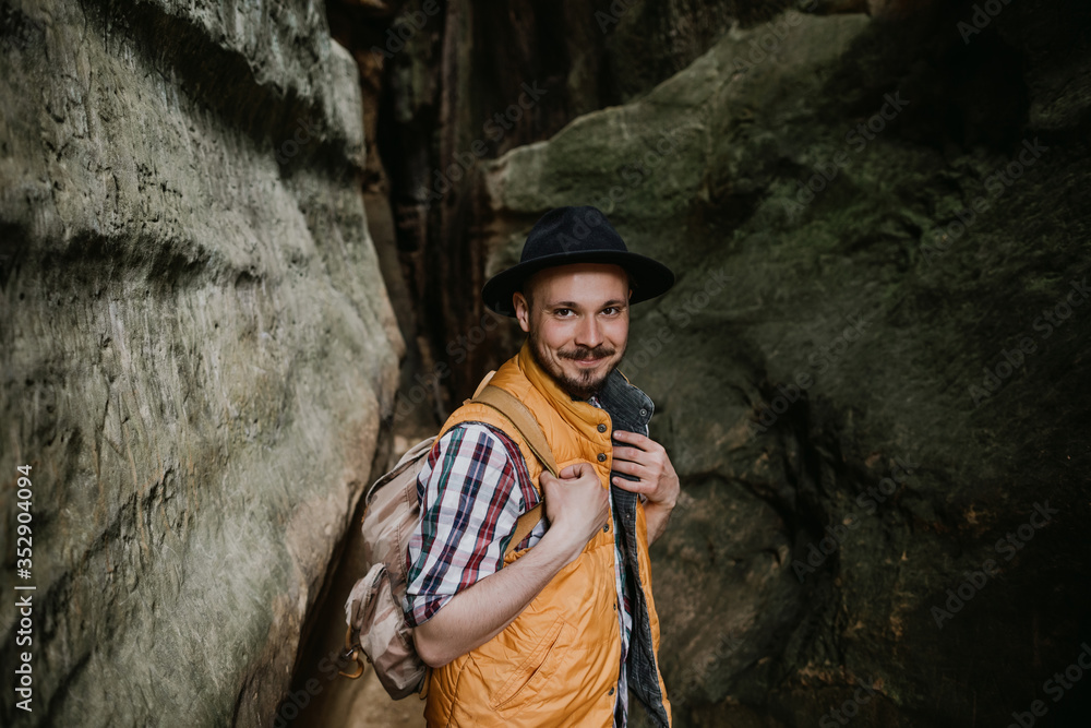 portrait of a young bearded man in hat standing on rock portrait of a young bearded man in hat standing on rock