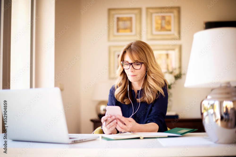 Shot of woman sitting behind her laptop and working from home Shot of woman sitting behind her laptop and working from home