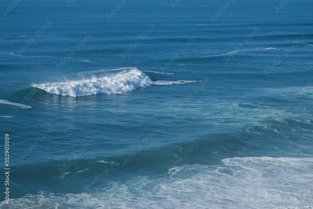 Big waves in Nazare, Portugal with small figures of surfers Big waves in Nazare, Portugal with small figures of surfers