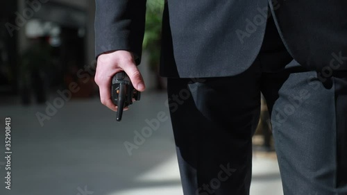 The guard holds a walkie-talkie in his hand. Hand of a security guard holding an intercom in his hand. photo