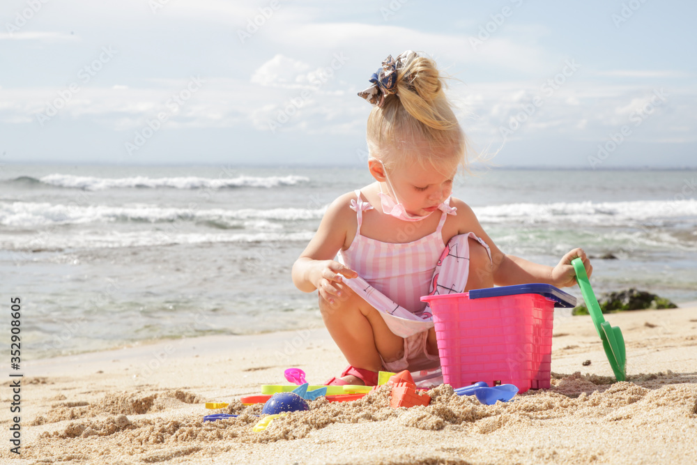 Summer vacation. Adorable toddler girl playing with beach toys on the sandy beach. Summer vacation. Adorable toddler girl playing with beach toys on the sandy beach.
