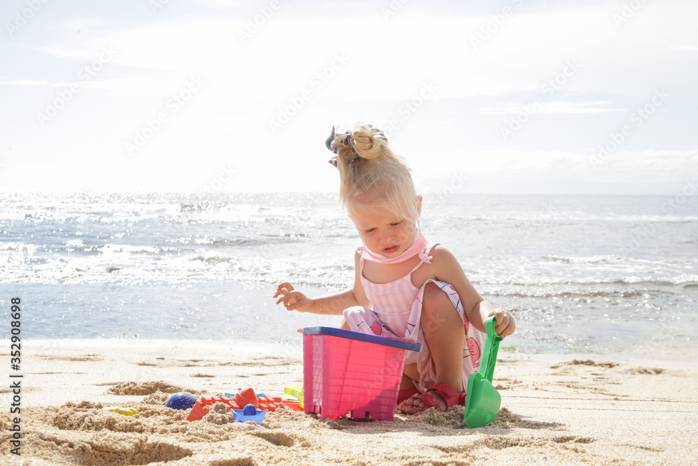 Summer vacation. Adorable toddler girl playing with beach toys on the sandy beach. Summer vacation. Adorable toddler girl playing with beach toys on the sandy beach.