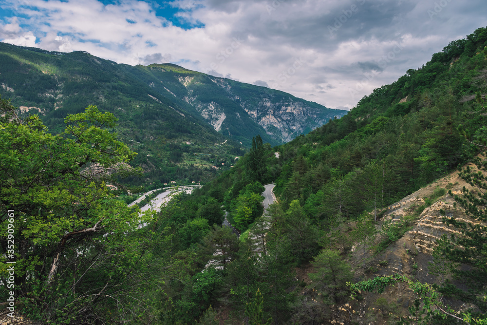 A picturesque wide panoramic view of an empty road in the valley of Var in the Alps mountains (Puget-Theniers, Alpes-Maritimes, France)