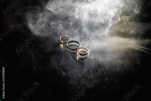 Three gold wedding rings on black background