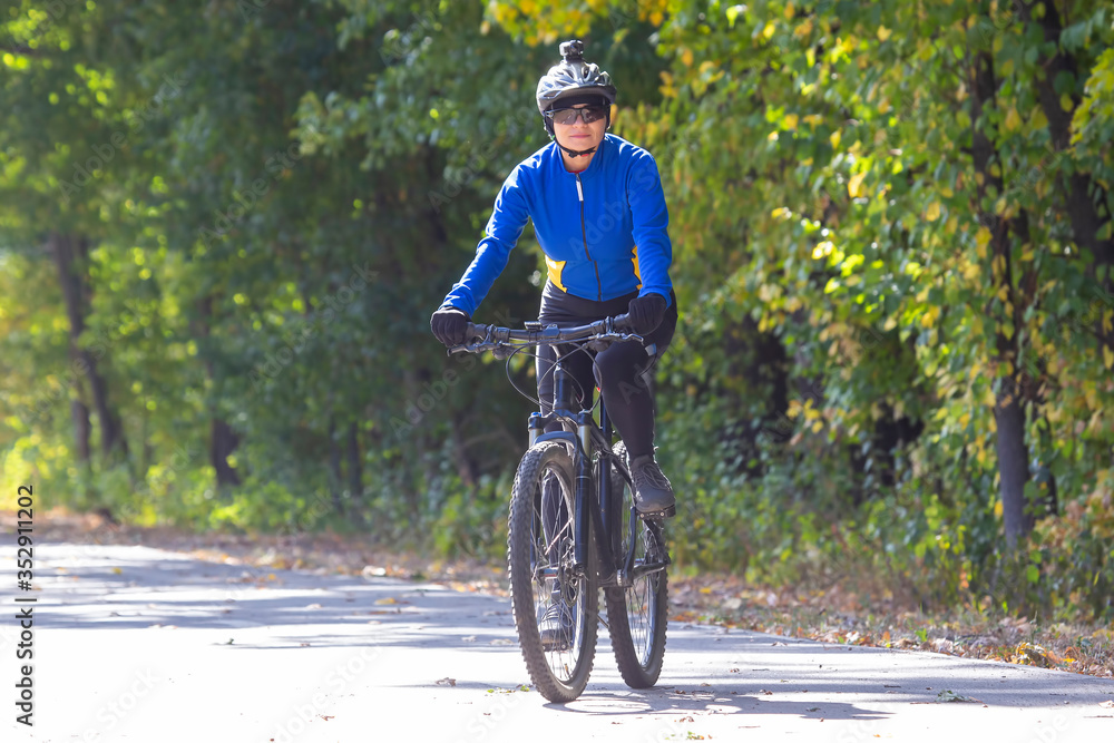 Obraz premium Beautiful girl cyclist rides a bicycle. Healthy lifestyle and sport. Leisure and hobbies