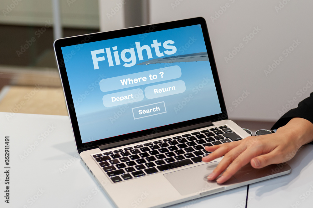 ノートパソコンで航空券のオンラインのフライト予約の画面を見せている女性の手 ノートパソコンで航空券のオンラインのフライト予約の画面を見せている女性の手