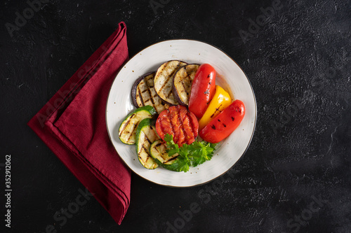 Grilled vegetables with parsley. Grilled eggplant, tomato, red and yellow bell peppers and zucchini.