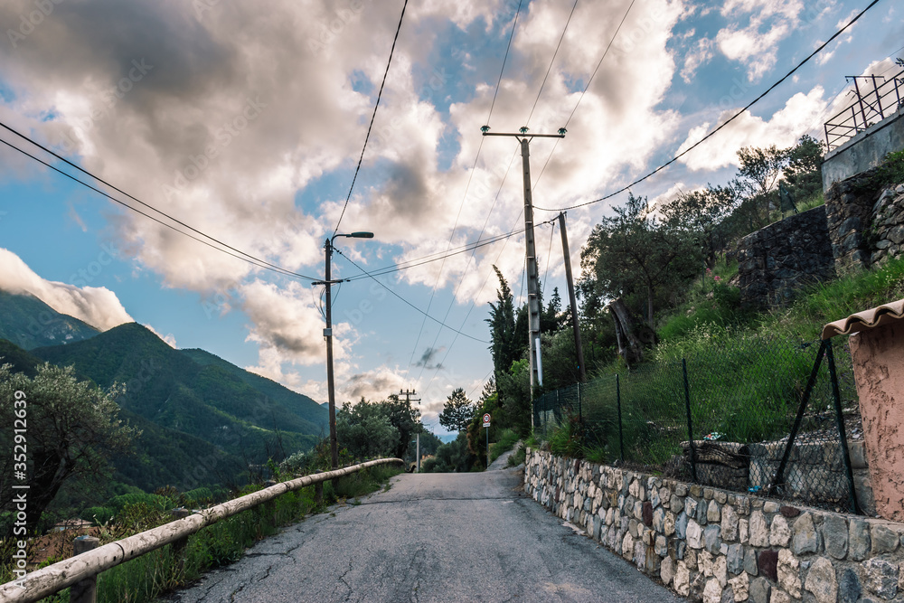 A picturesque view of an empty rural road in a medieval village in the low French Alps mountains in the early evening (Puget-Theniers, Alpes-Maritimes, France) A picturesque view of an empty rural road in a medieval village in the low French Alps mountains in the early evening (Puget-Theniers, Alpes-Maritimes, France)
