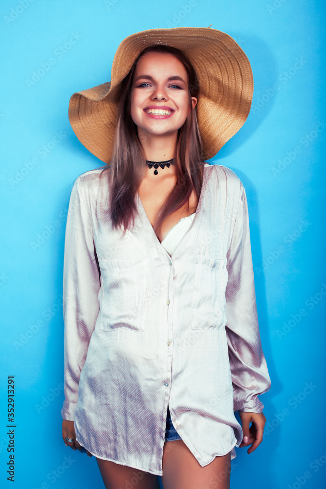 young pretty girl in big hat posing happy smiling on blue background, lifestyle people on summer vacation concept young pretty girl in big hat posing happy smiling on blue background, lifestyle people on summer vacation concept