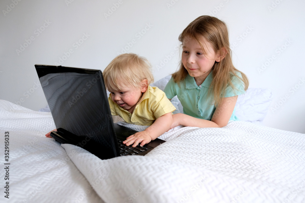 little girl and boy are watching cartoons on a laptop little girl and boy are watching cartoons on a laptop
