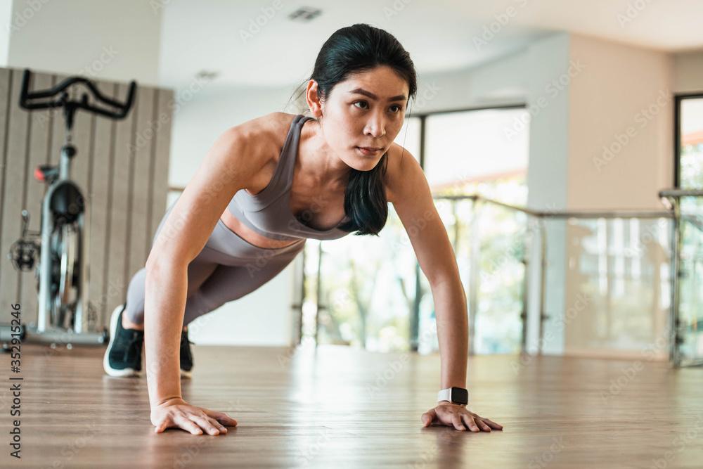 Beautiful young Asian woman doing push ups in the gym Beautiful young Asian woman doing push ups in the gym