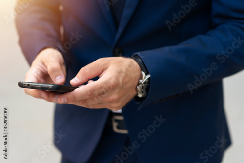 Man in suit holding phone and sending text closeup © Dexon Dee
