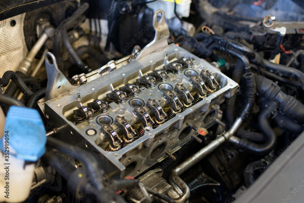 Engine repair of a modern car. Disassembled engine on a car for repair focus in the center. Technical photo. Engine repair of a modern car. Disassembled engine on a car for repair focus in the center. Technical photo.