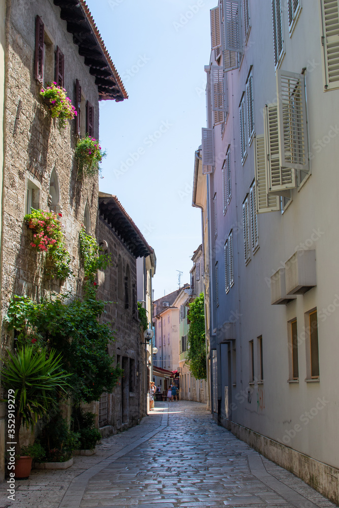 Narrow alley with colorful croatian houses in the old town of Porec (Parenzo), Croatia