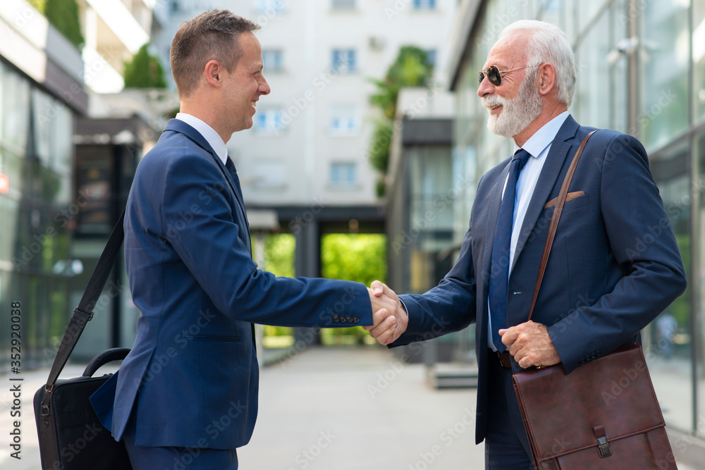 Young man shake hands with senior business man Young man shake hands with senior business man