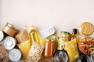 Flat lay view at kitchen table full with non-perishable foods. Space for text