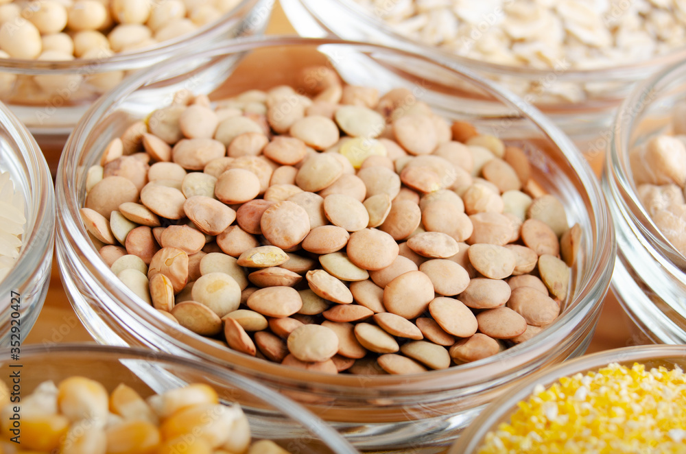Lentils closeup in glass bowl on wooden kitchen table, non-perishable, long shelf life food concept Lentils closeup in glass bowl on wooden kitchen table, non-perishable, long shelf life food concept