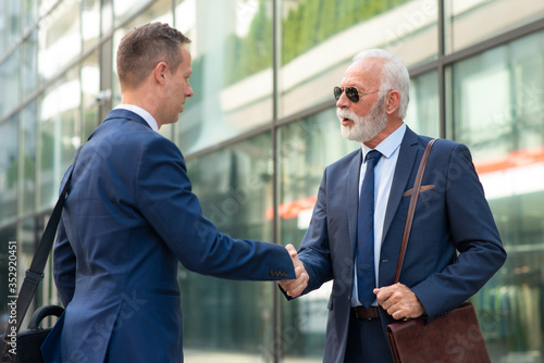 Young man shake hands with senior business man