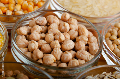 Chickpeas closeup in glass bowl on wooden kitchen table, non-perishable, long shelf life food concept