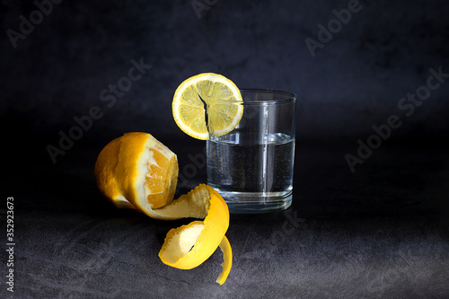 glass with water and lemon on a black background