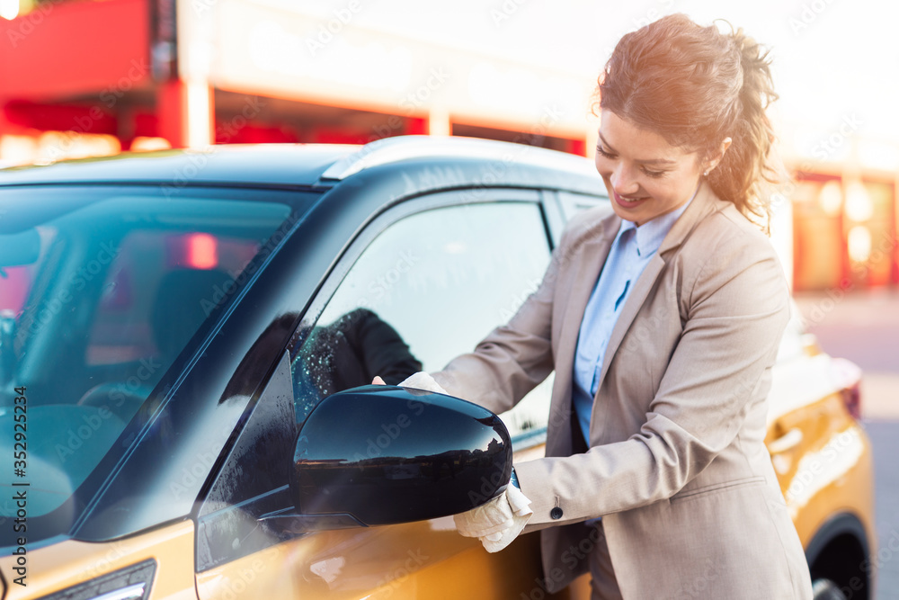 Businesswoman washing car at car wash station.