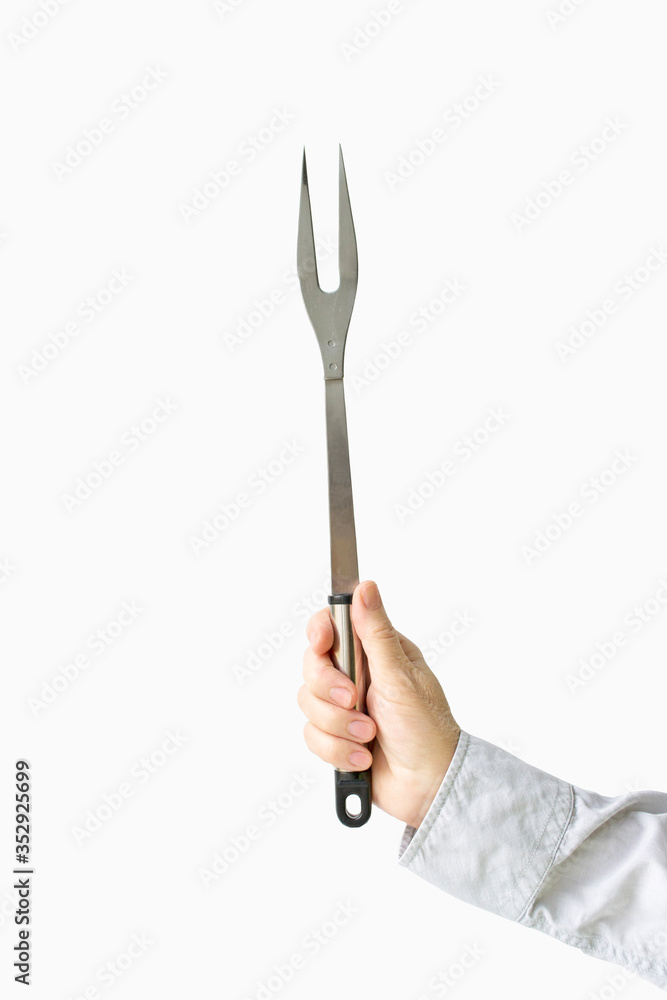 Barbecue fork in female hands on a white background Barbecue fork in female hands on a white background