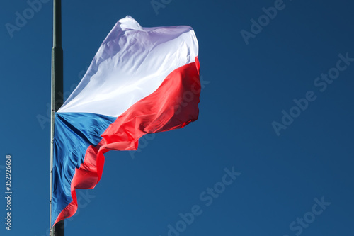 A lowered Czech flag flutters in the wind.