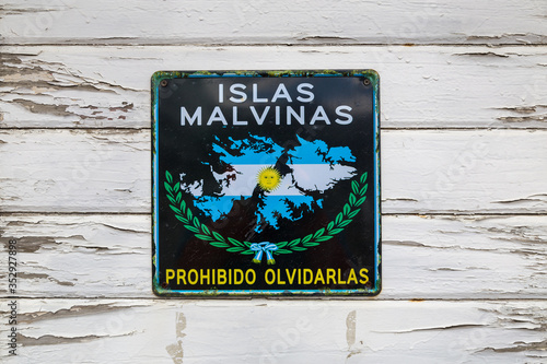 Sign plate with 'Islas Malvinas - forbidden to forget' words on old white wooden wall in Ushuaia port, Tierra del Fuego province, Argentina photo