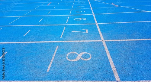 blue athletic track with the numbers of the lanes