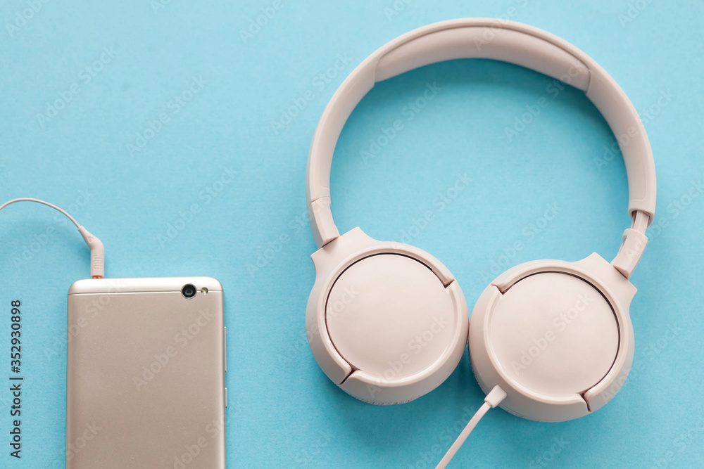 Earphones with smartphone on blue background Earphones with smartphone on blue background