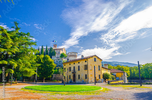 Castle of Brescia medieval building or Castello di Brescia or Falcon of Italy on Cidneo Hill with green park in historical city centre, blue cloudy sky background, Lombardy, Northern Italy photo