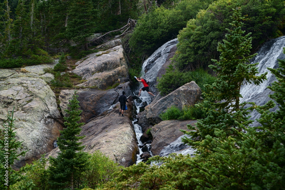 Man jumping over a rocky mountain stream