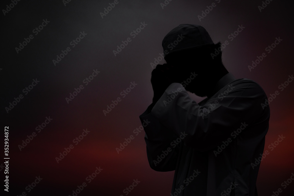 Silhouette Young asian muslim man praying on sunset,Ramadan festival concept Silhouette Young asian muslim man praying on sunset,Ramadan festival concept