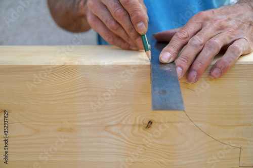 Dovetail joint. male Hand of carpenter is measuring angle of Natural Wooden beam. Preparation for cutting with a saw. Wooden beams spruce for outdoor construction, for carport. woodwork concept. 