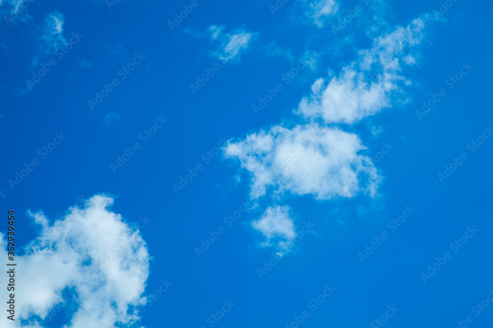 Obraz premium White clouds on a back of blue sky. Clear sky with fluffy light clouds.