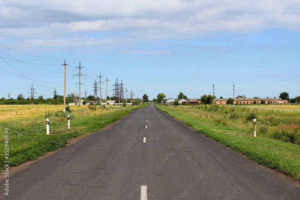 An empty asphalt road through the rural landscape.