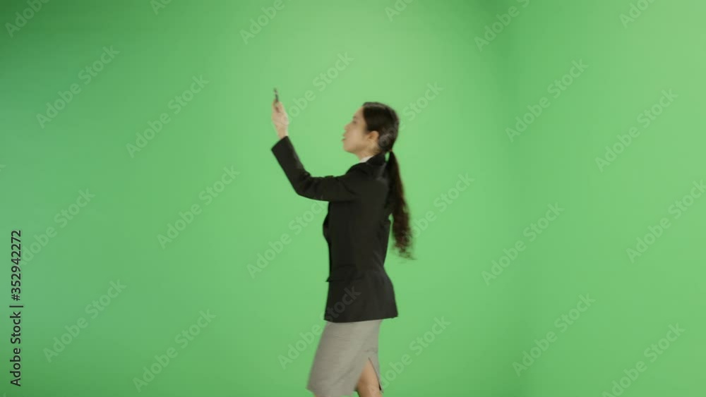 Businesswoman trying find phone signal on green screen Businesswoman trying find phone signal on green screen
