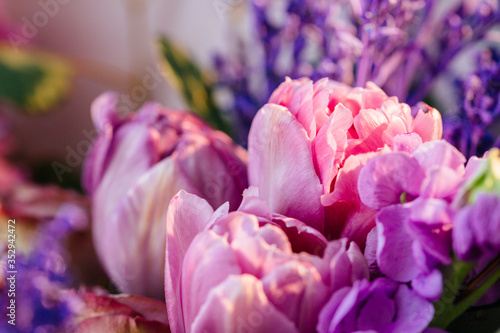 Stylish colorful floral bouquet with purple and pink tulips and roses. Designer flower bouquet from a florist. Beautiful blossoming flower  wedding bouquet. Close up