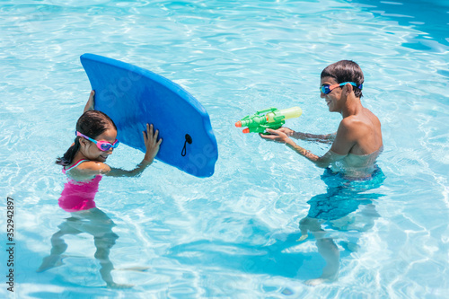 Bild auf Leinwand Brother and sister playing in the pool