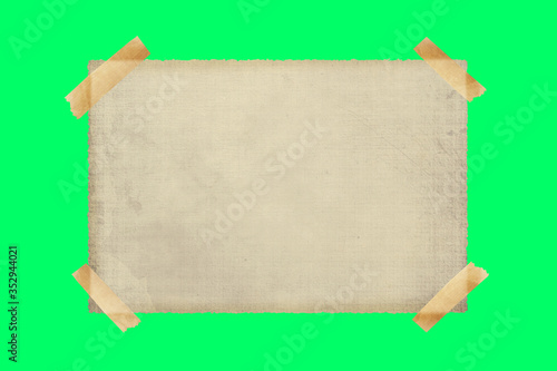 old paper stopped with adhesive tape on a green screen background. Copy space, ideal for inserting text. sheet of old lino