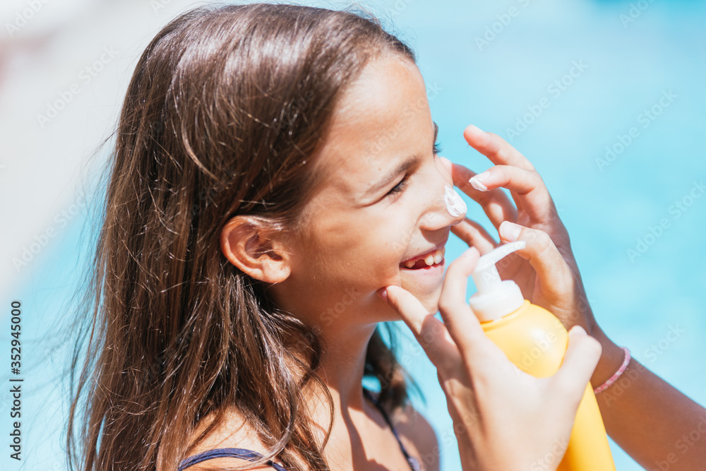 Little girl applying sun protection on summer vacation Little girl applying sun protection on summer vacation