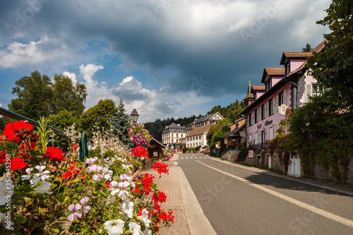 Fototapeta Naklejka Na Ścianę i Meble -  Flowering village in Alsace. Sunlit streets full of flowers.